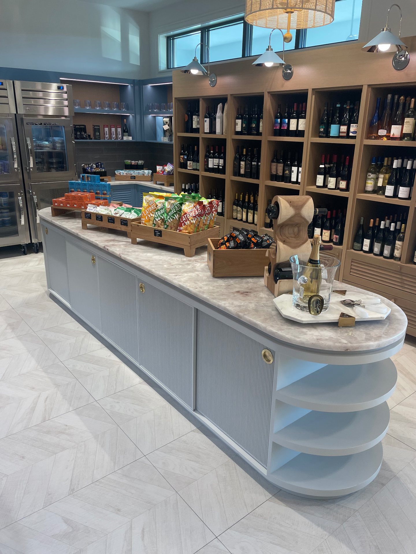 Curved market island with fluted panels and custom wine display millwork