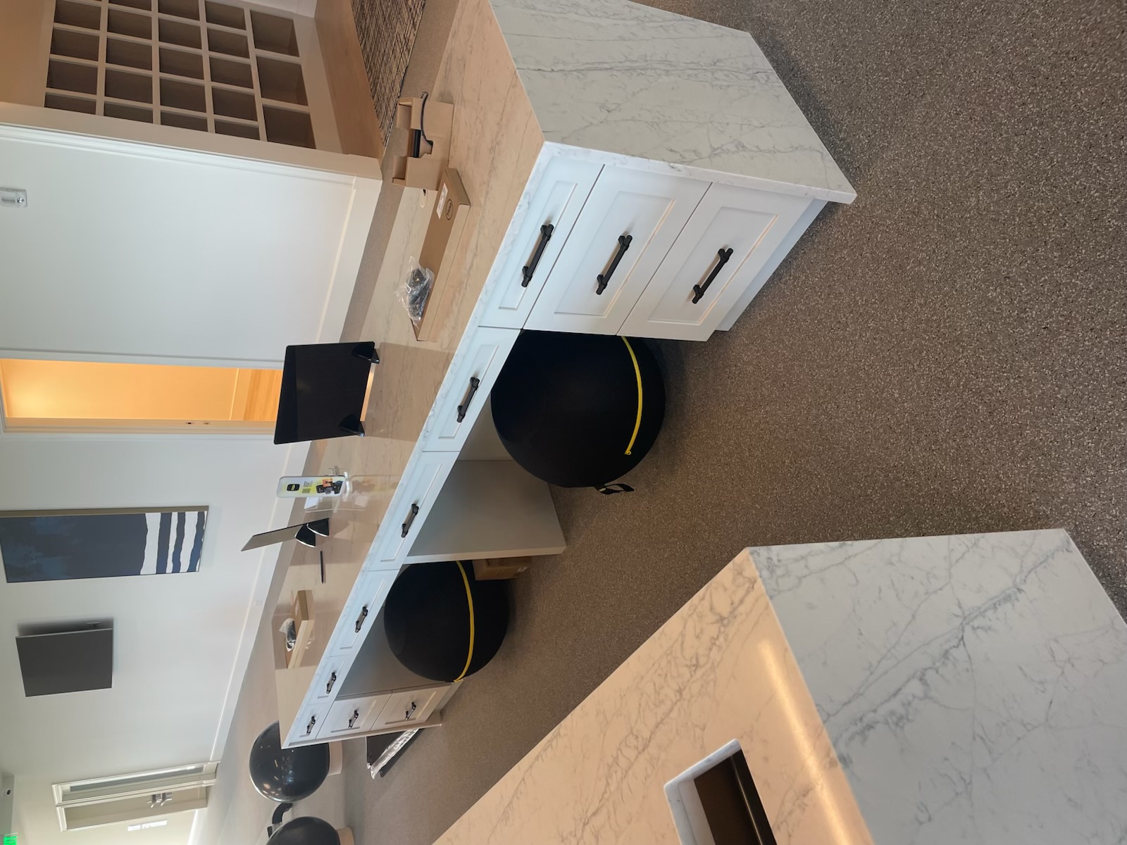 Custom built-in workstation with white shaker drawers and waterfall marble countertop